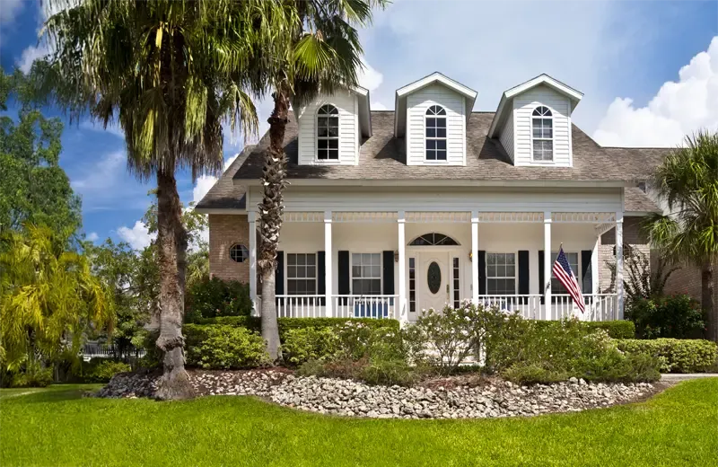 coastal home with green healthy lawn and nice landscaping