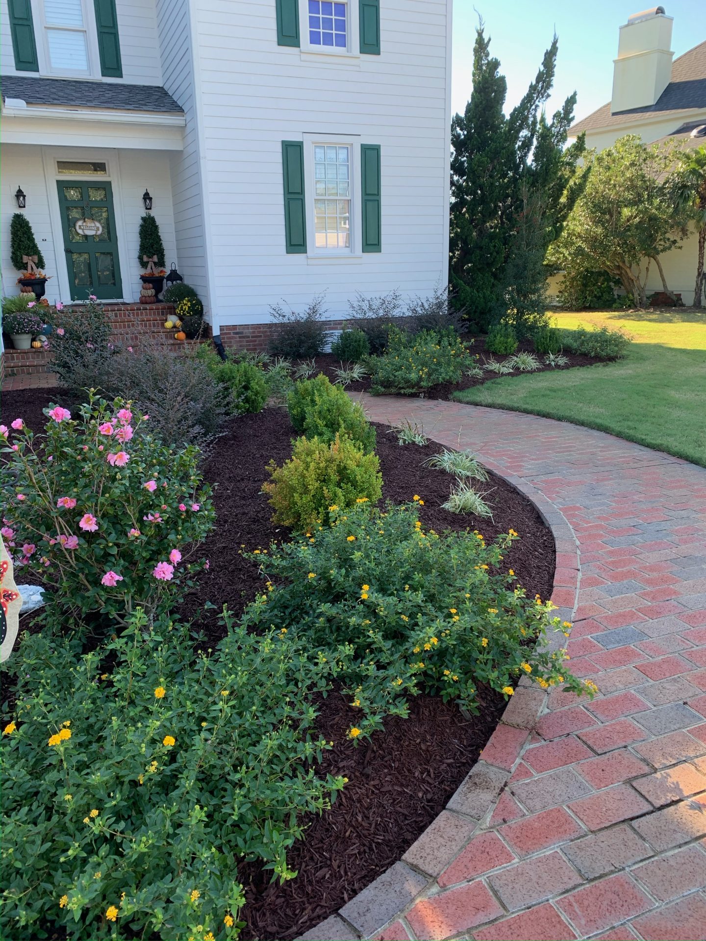 Beautiful garden with brick pathway and flowers.