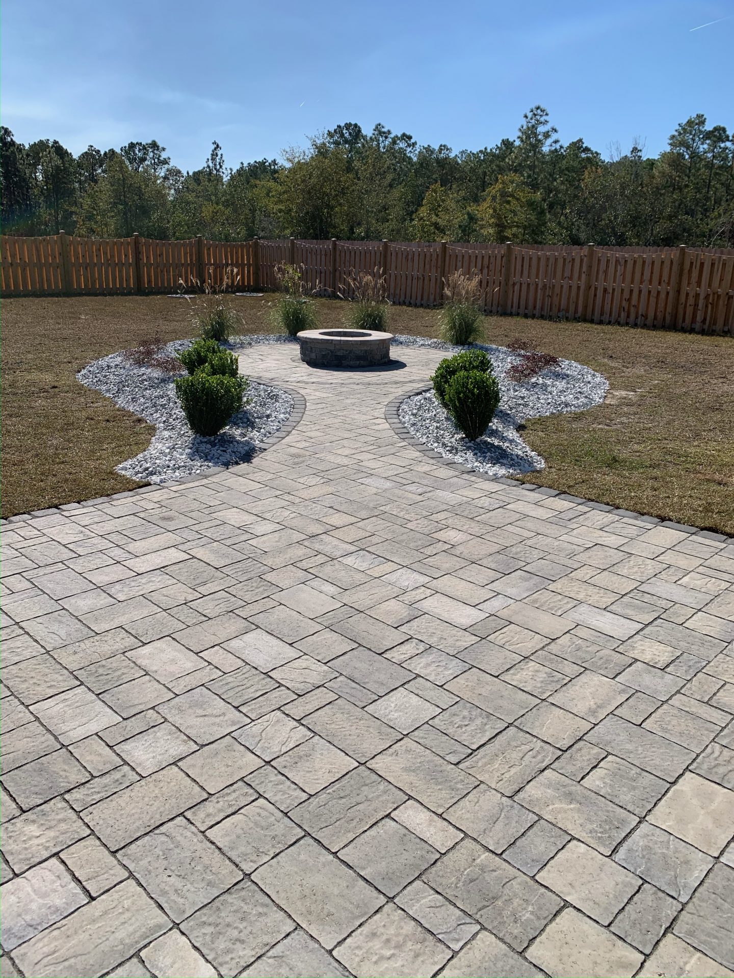 Backyard with stone patio and fire pit.