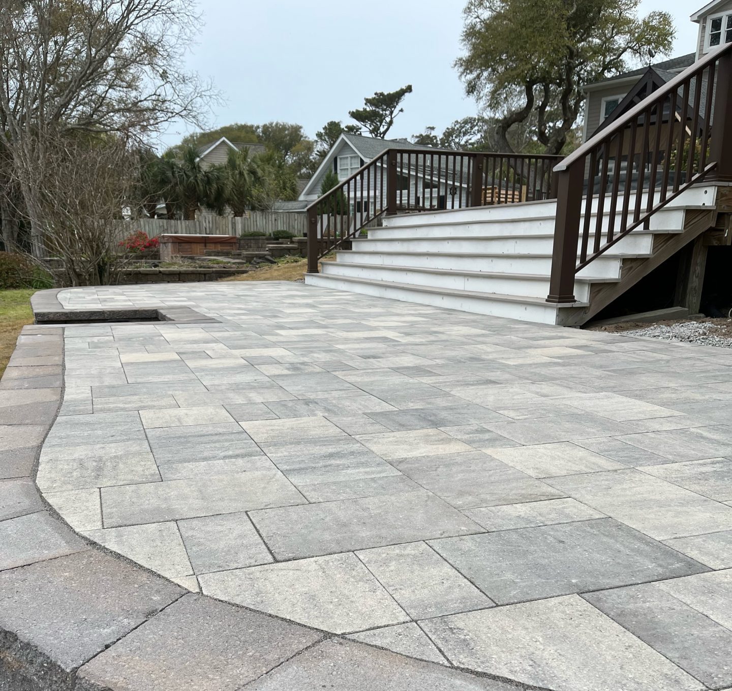 Paved patio with stairs in residential backyard.