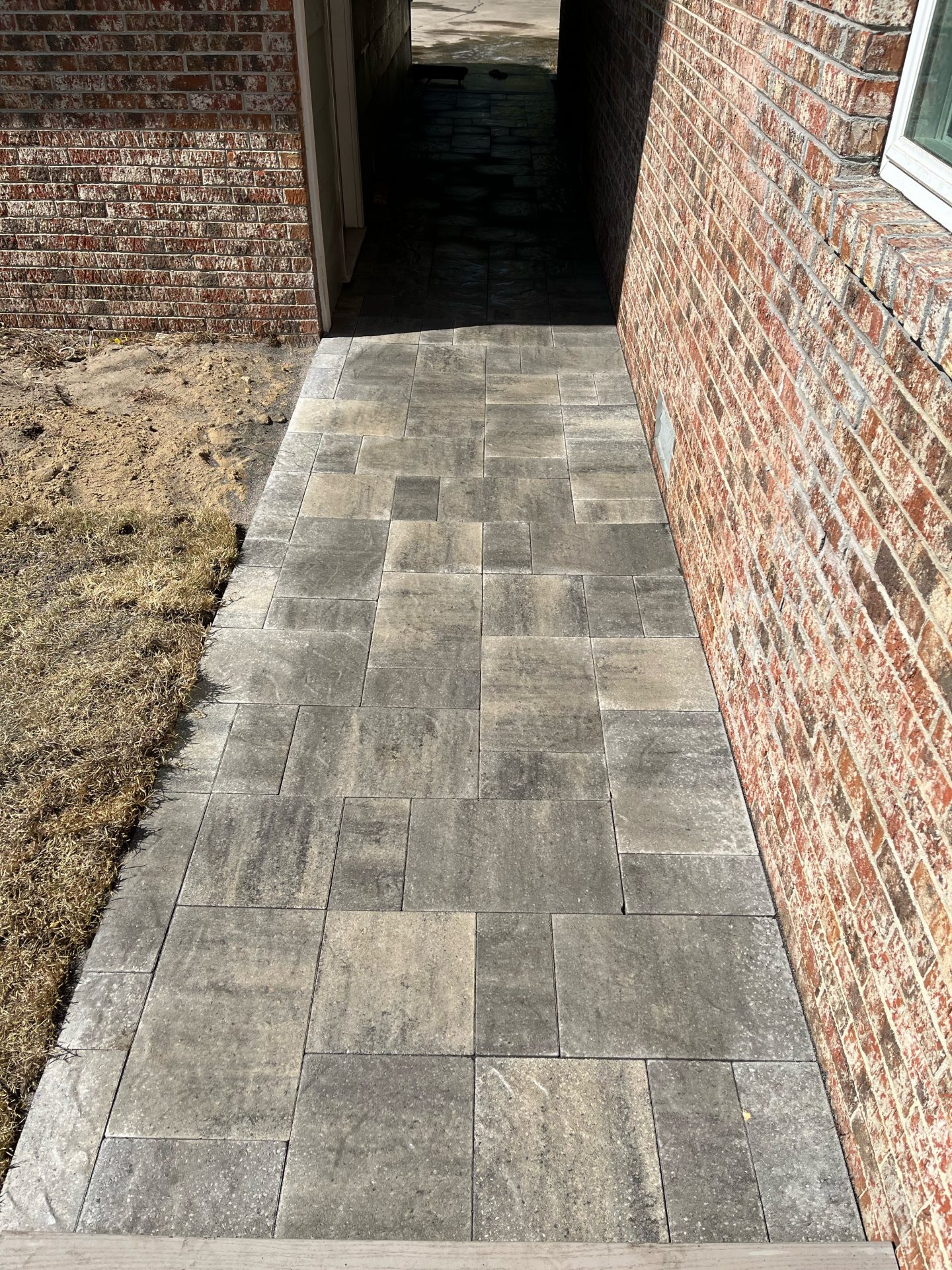 Brick walkway beside house with shadows