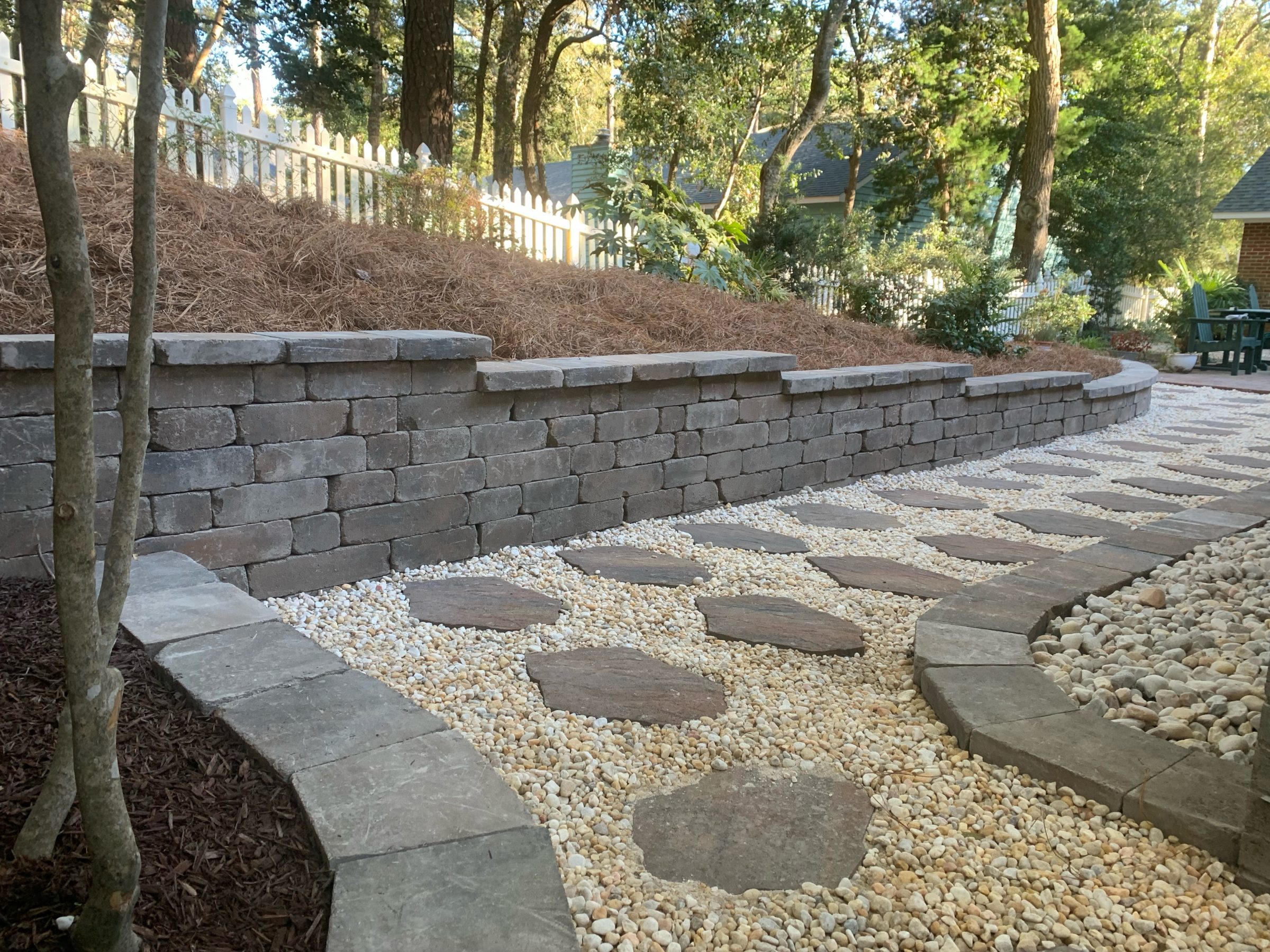 Stone path with brick retaining wall in garden.