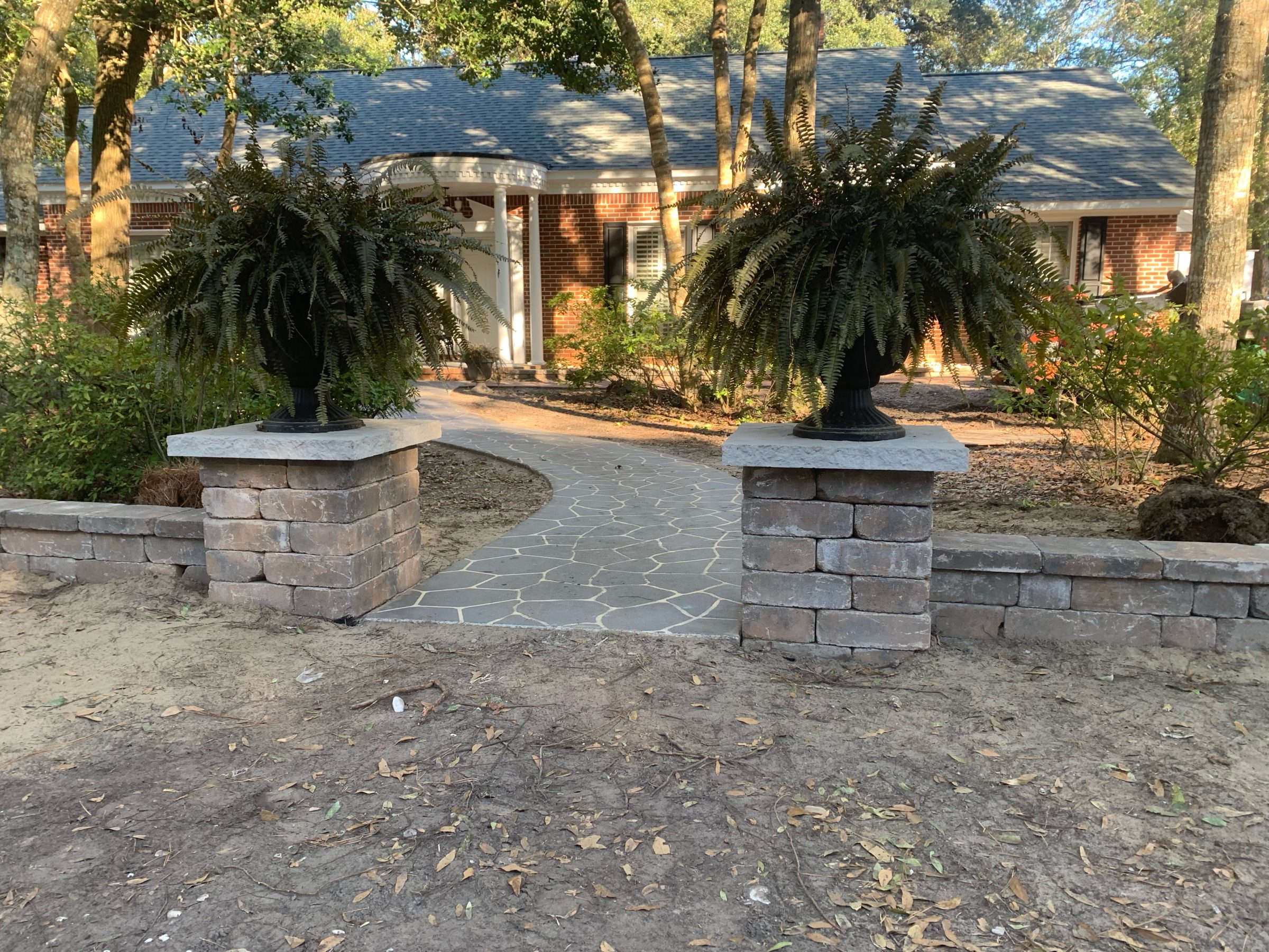 House entrance with brick path and ferns.
