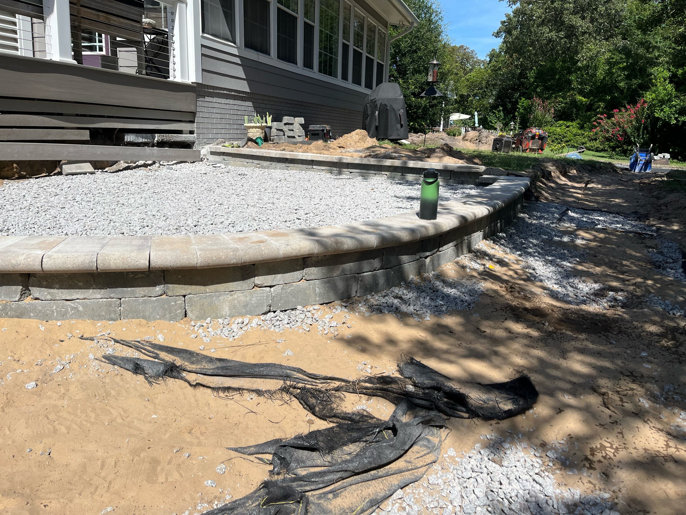 Backyard patio construction with stone steps and gravel.