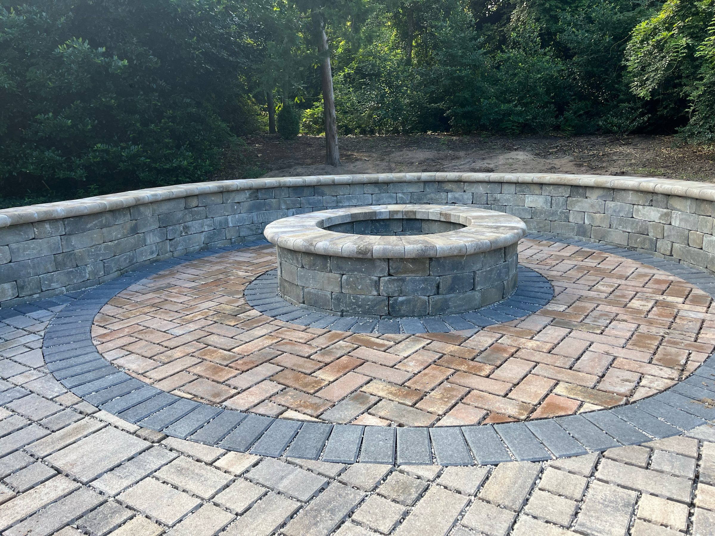 Circular stone fire pit with brick patio.