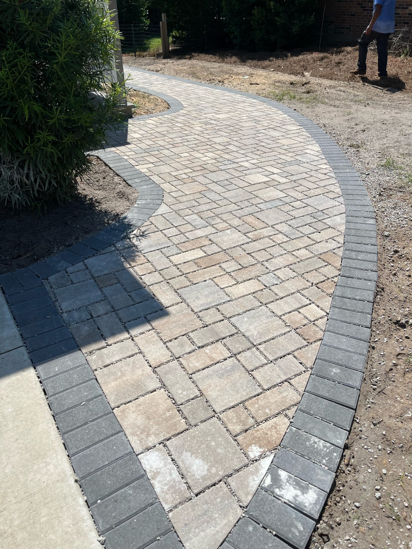 Curved brick path with gray border in progress