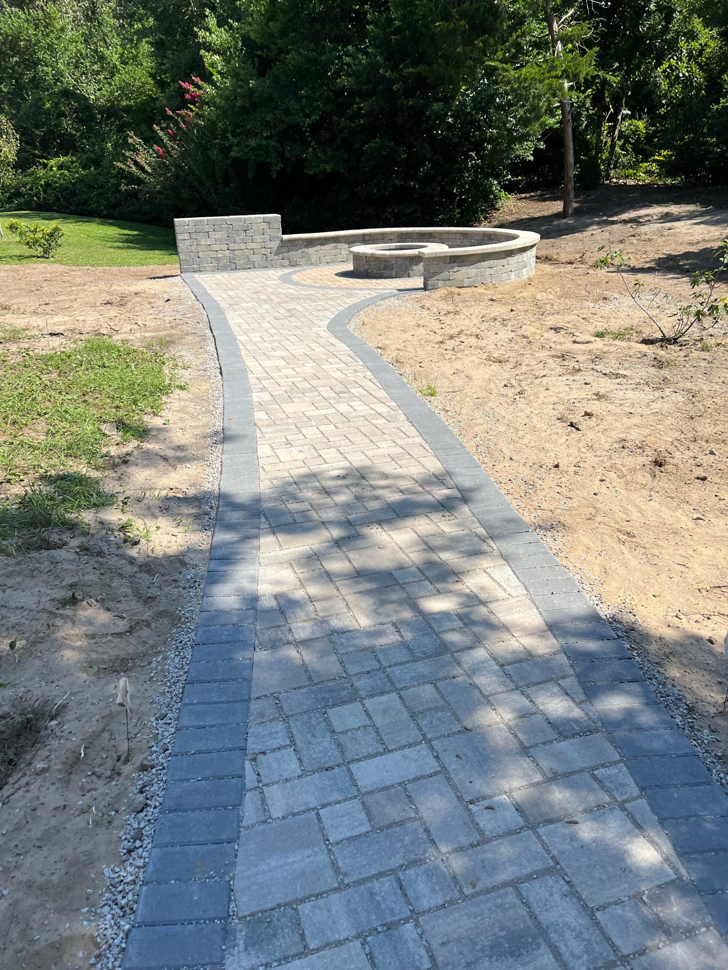 Brick pathway leading to circular stone seating area.