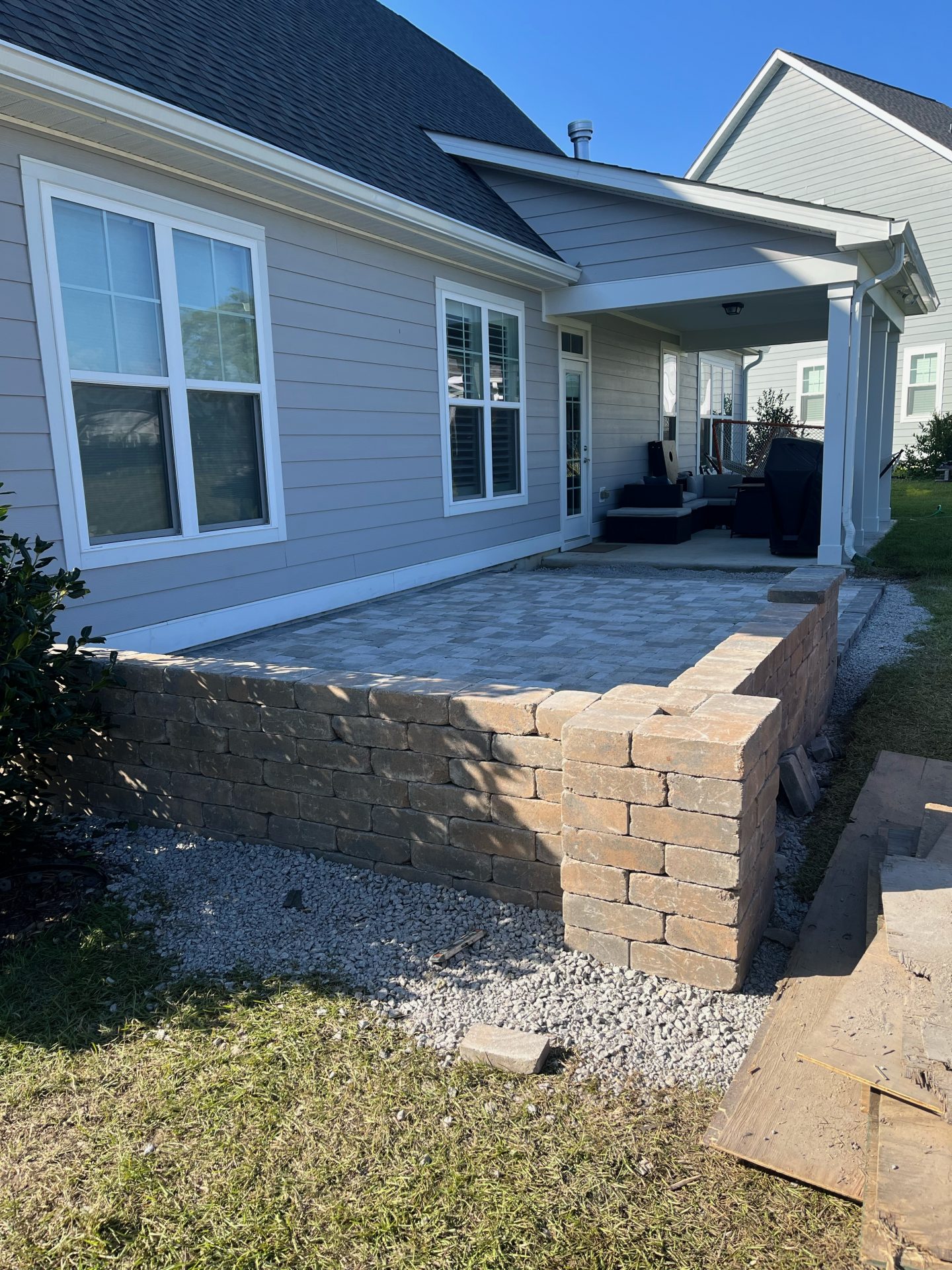 Brick patio with seating area and stone wall