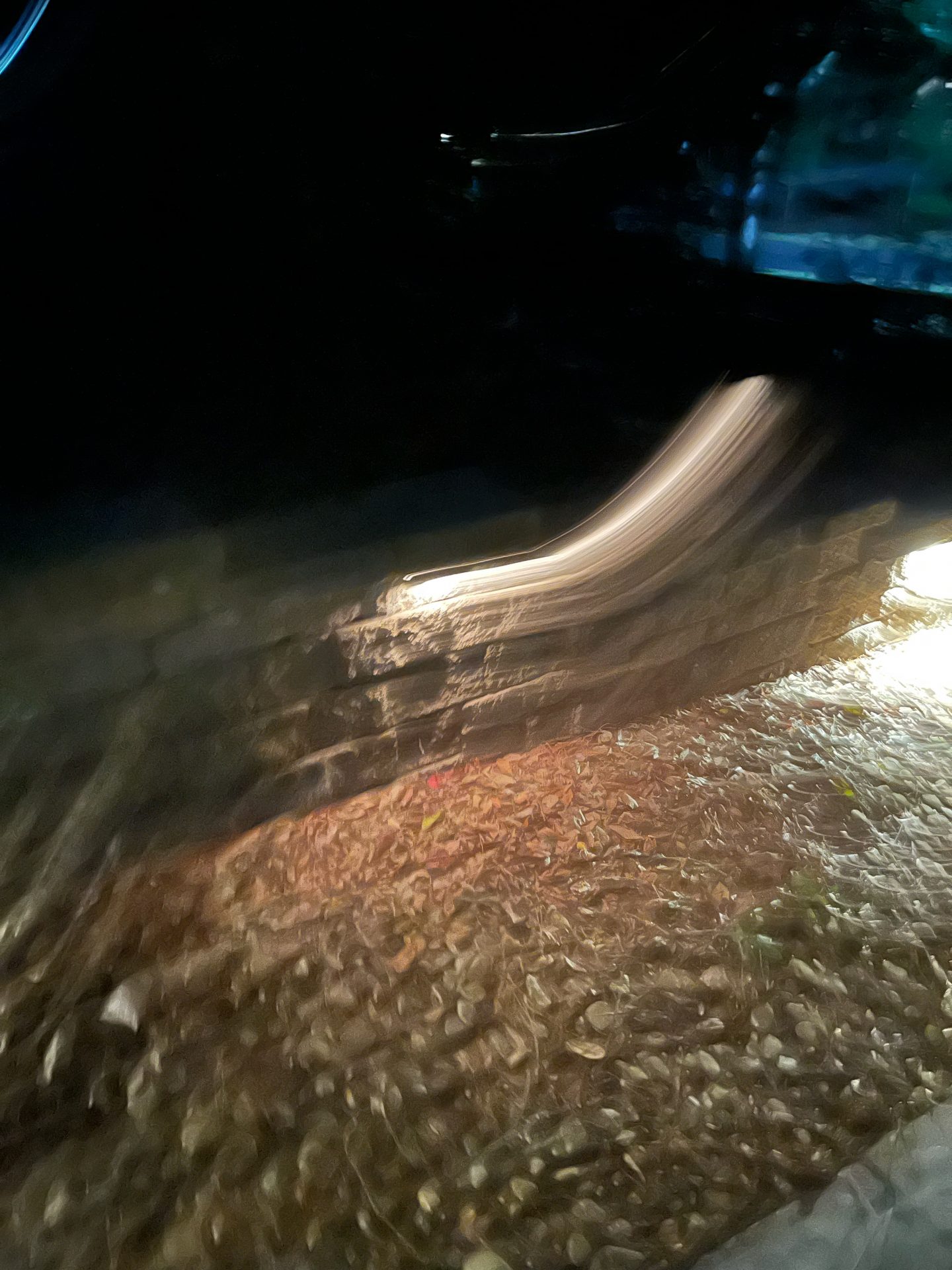 Blurred night scene with stone wall and ground