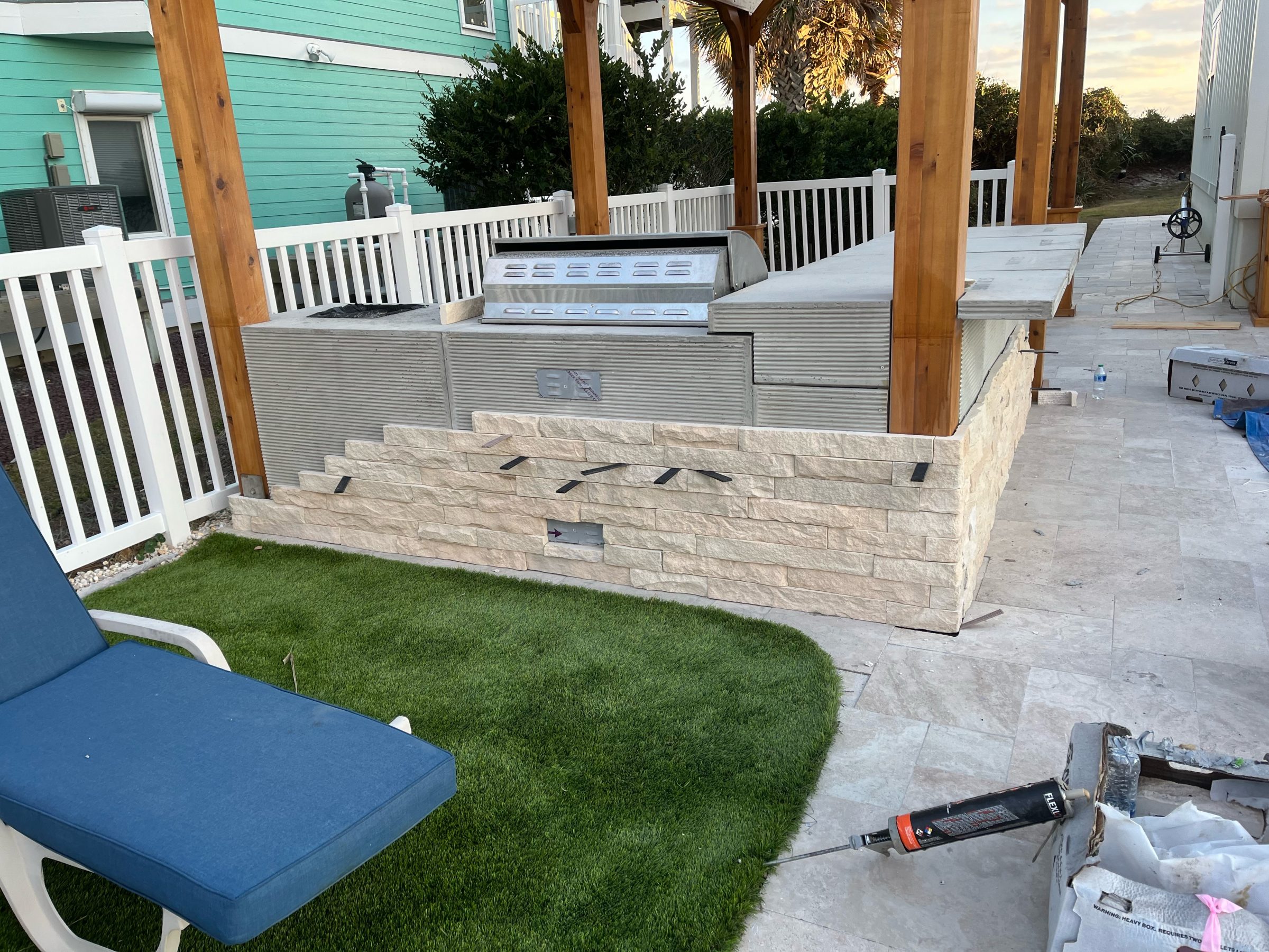 Outdoor kitchen construction near poolside patio