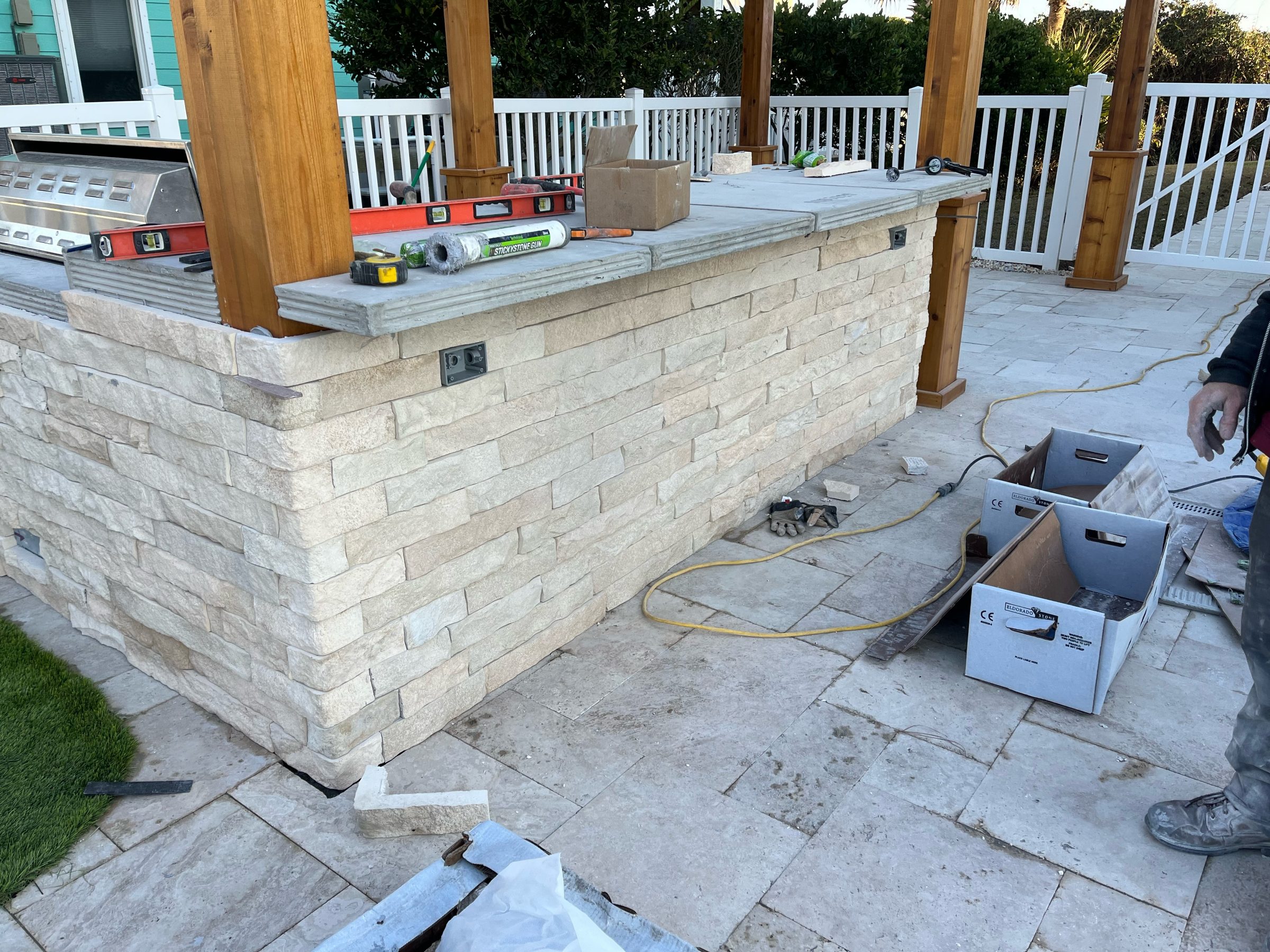 Outdoor kitchen construction with stone veneer.