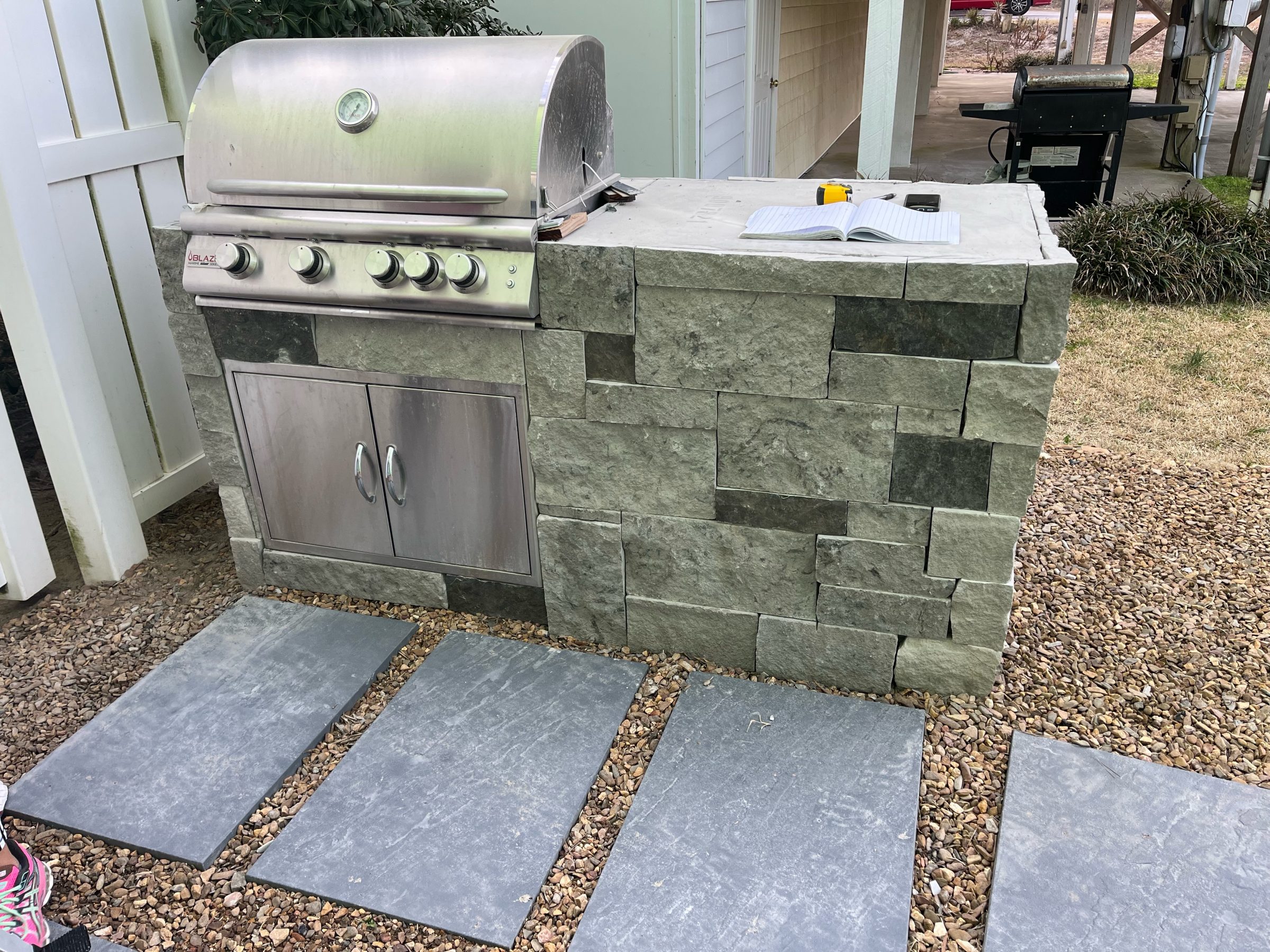 Outdoor stone grill with open notebook on top.