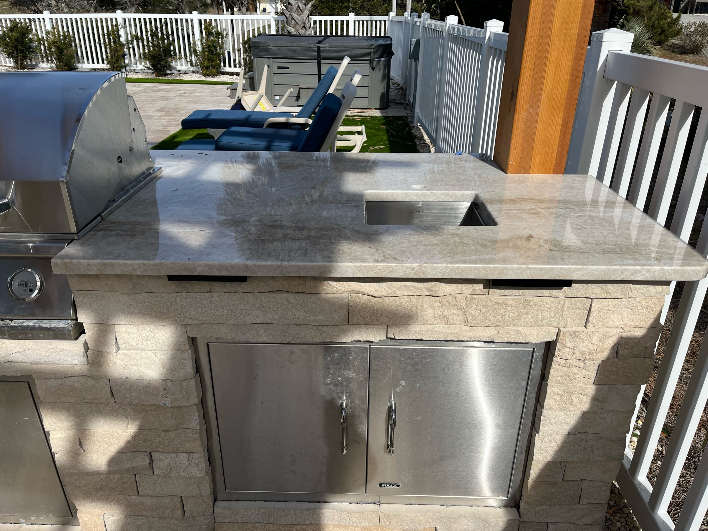 Outdoor kitchen with a stainless steel grill.