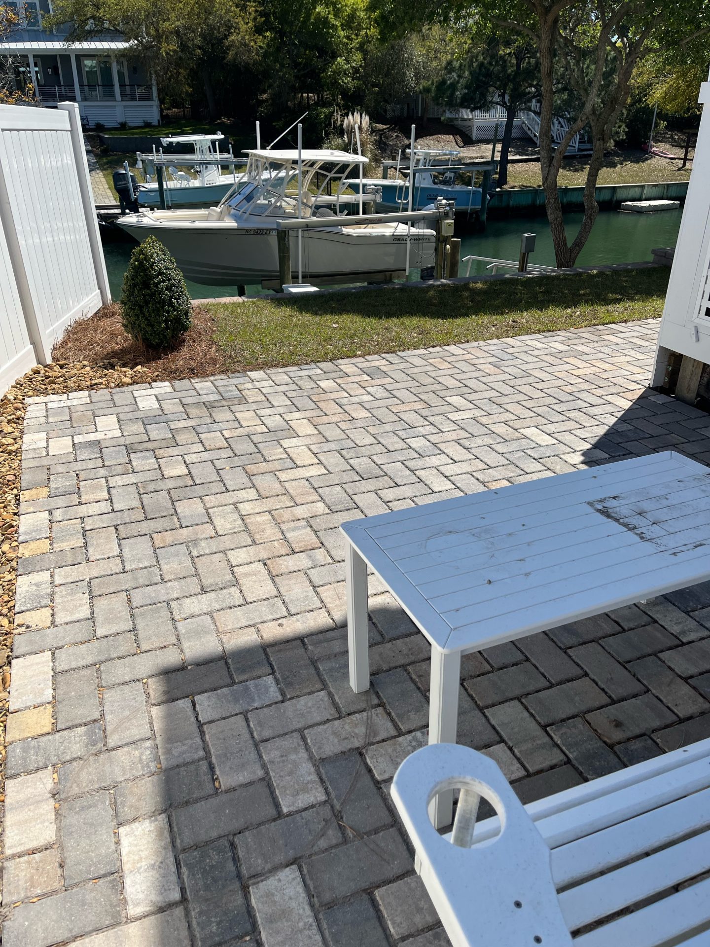 Patio with pavers overlooking boats on canal.
