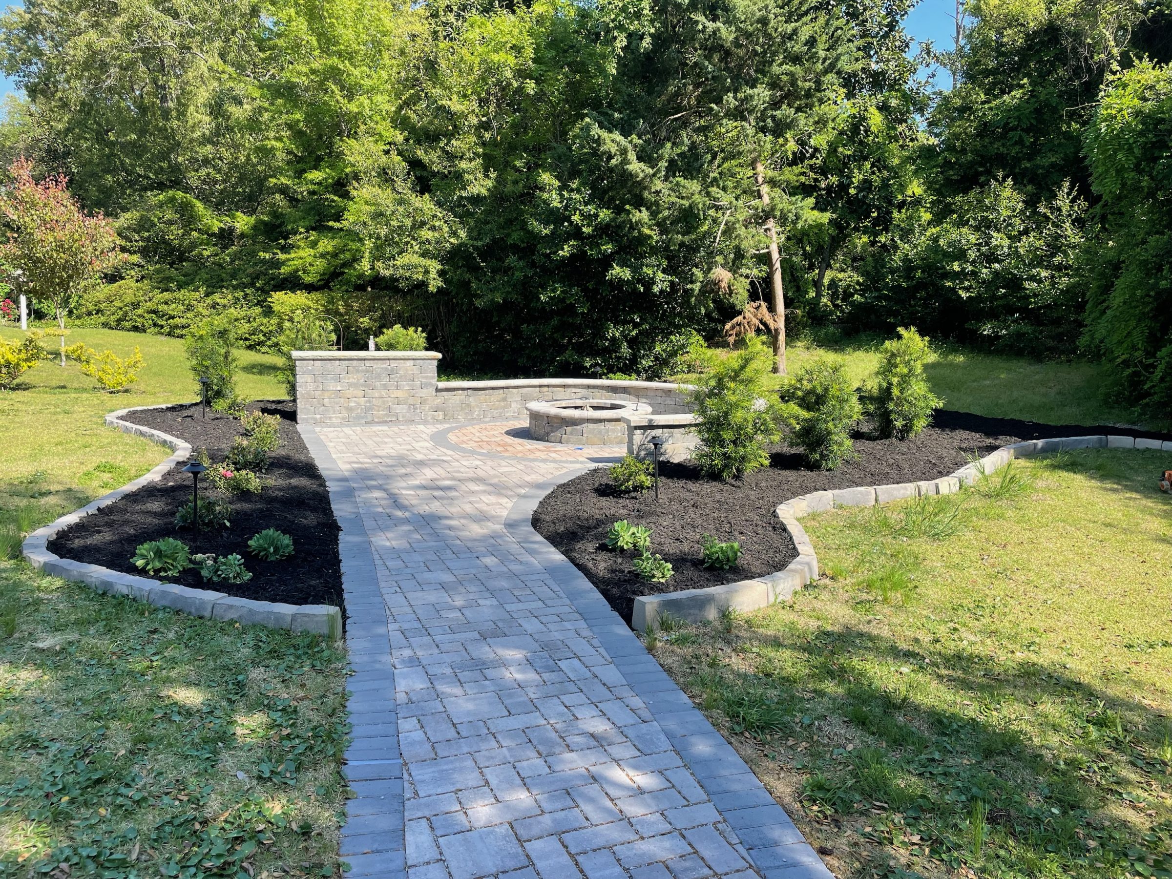 Brick pathway leading to backyard garden area.