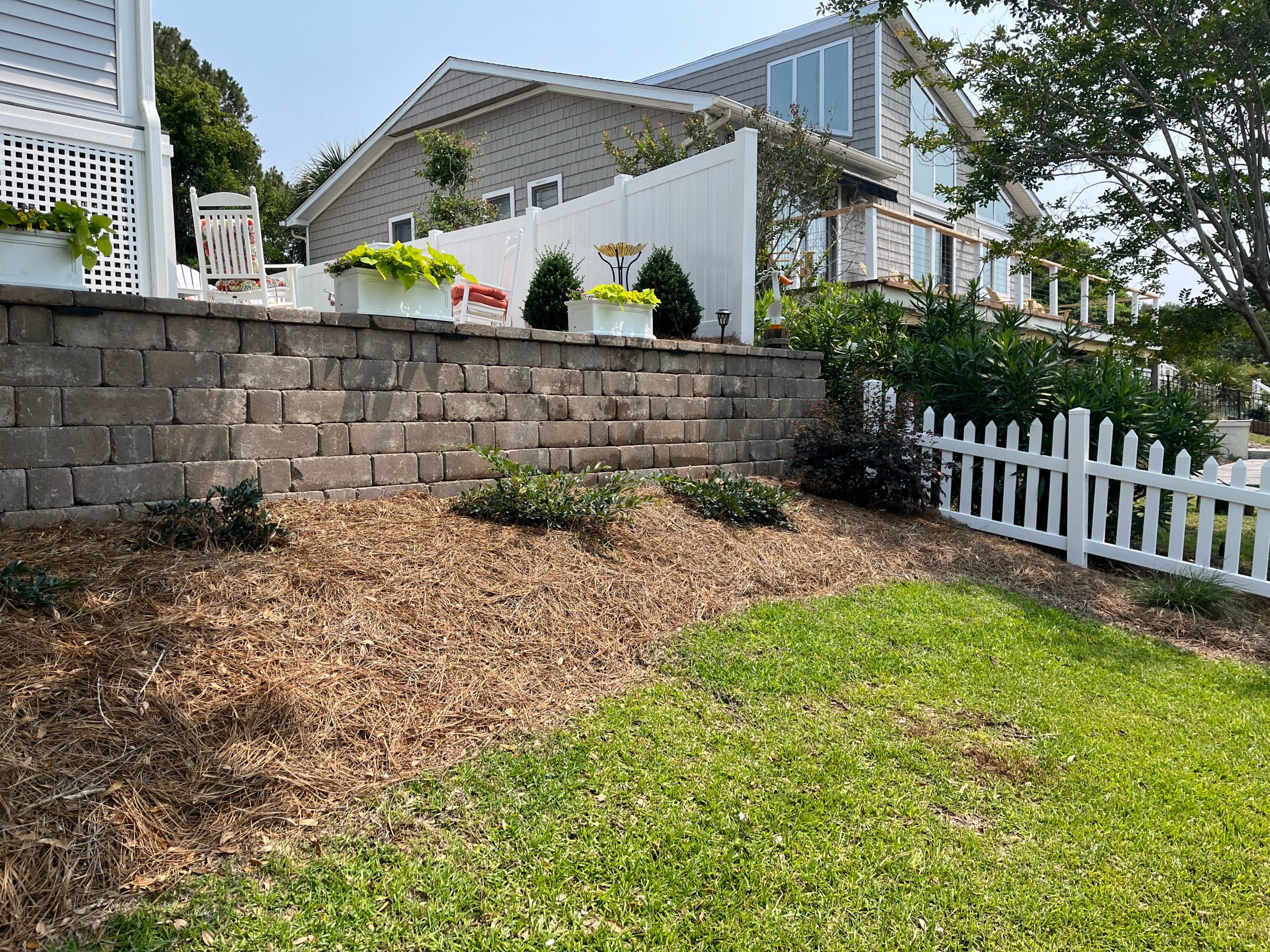 House with garden, patio wall, and white fence