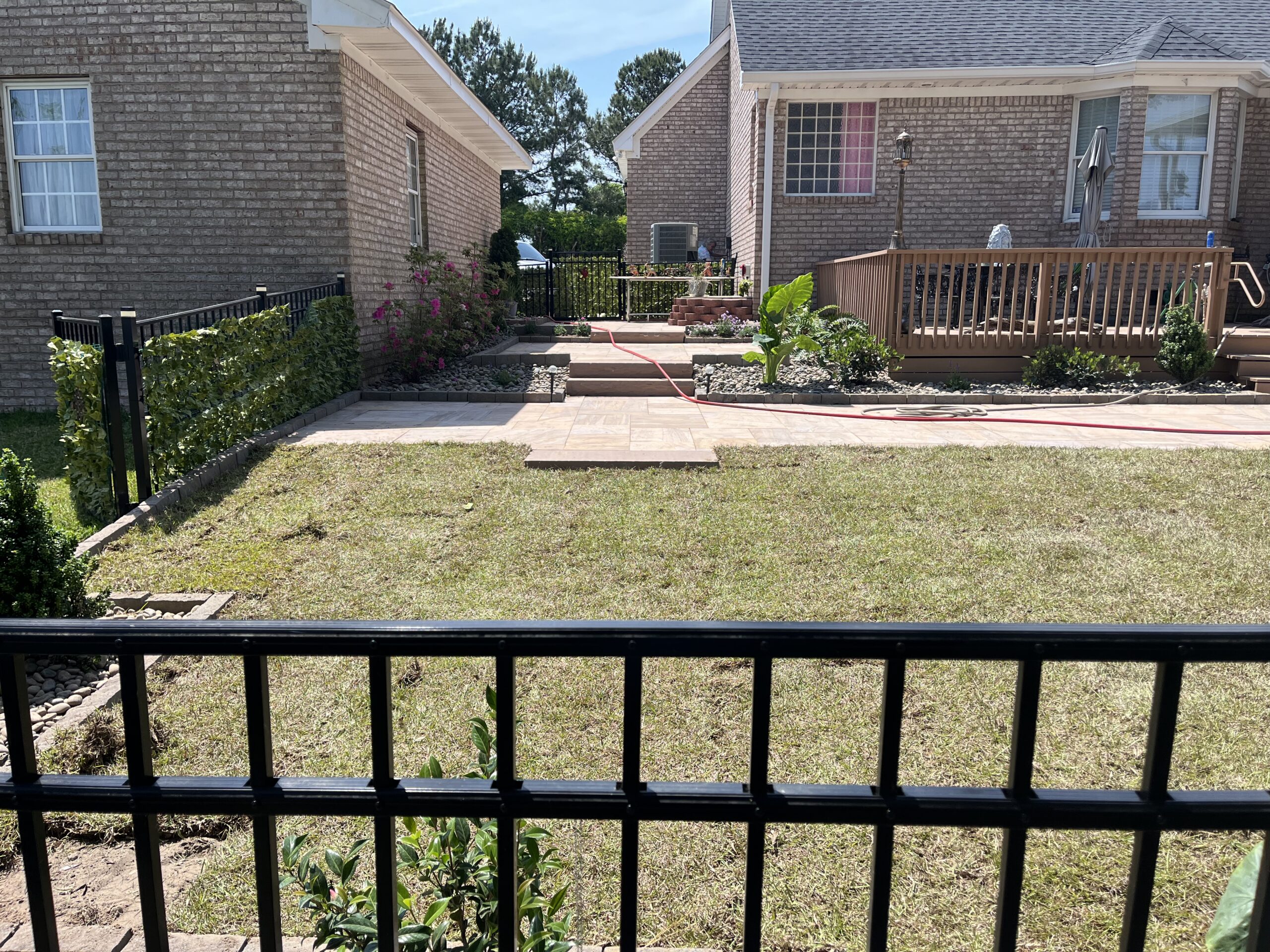 Backyard with deck and patio, fenced lawn view.