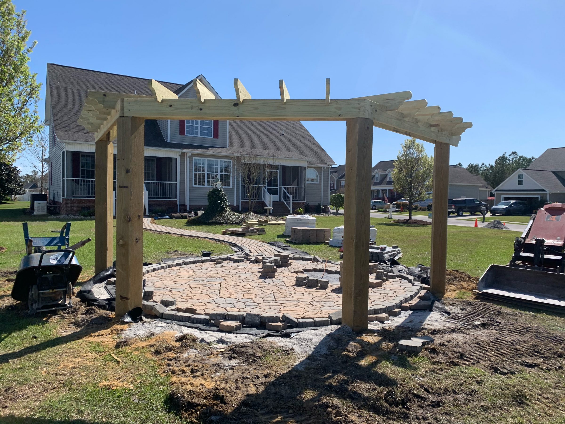 Construction of backyard pergola and patio in progress.