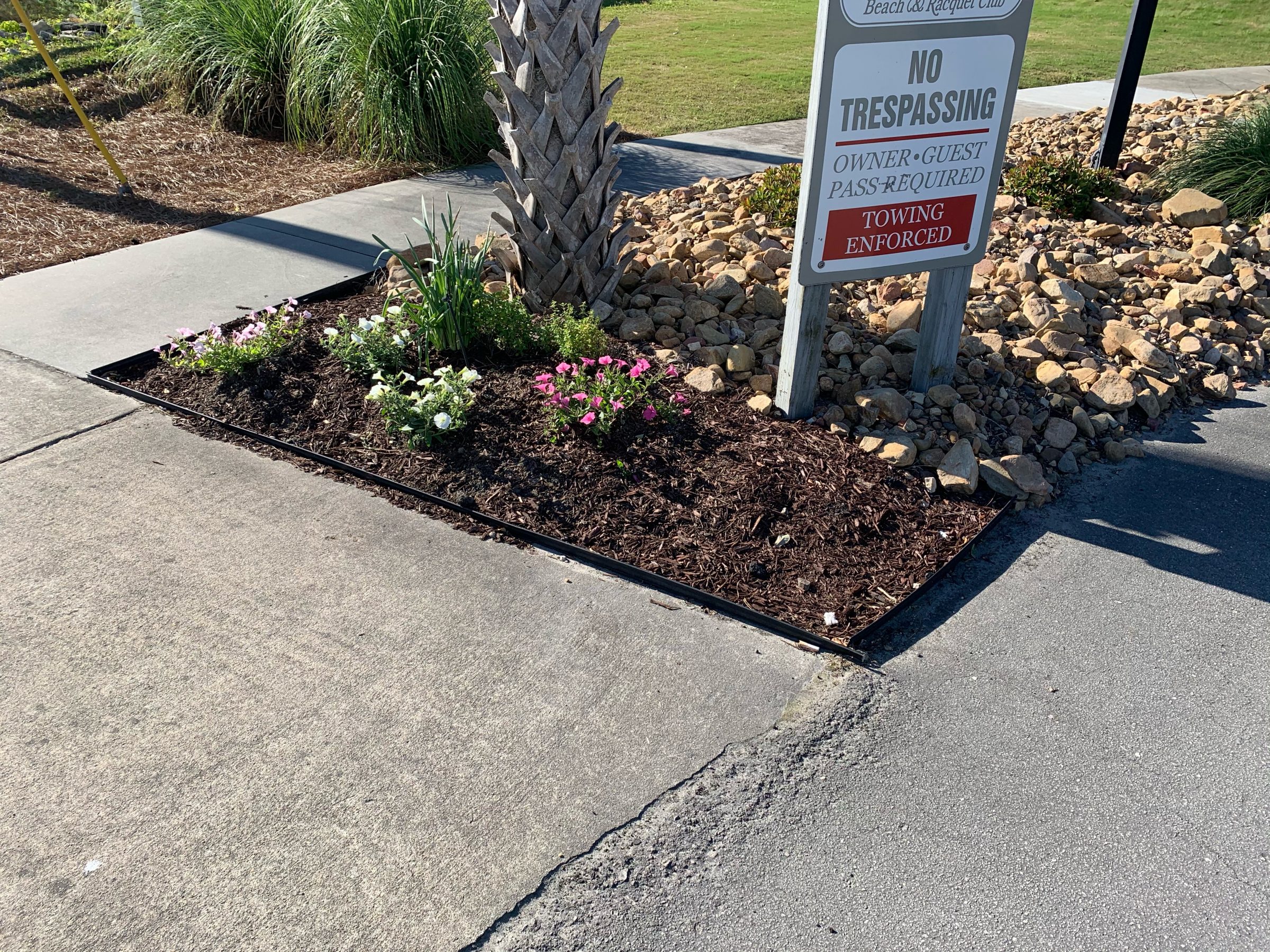 Flowerbed near a no trespassing sign.