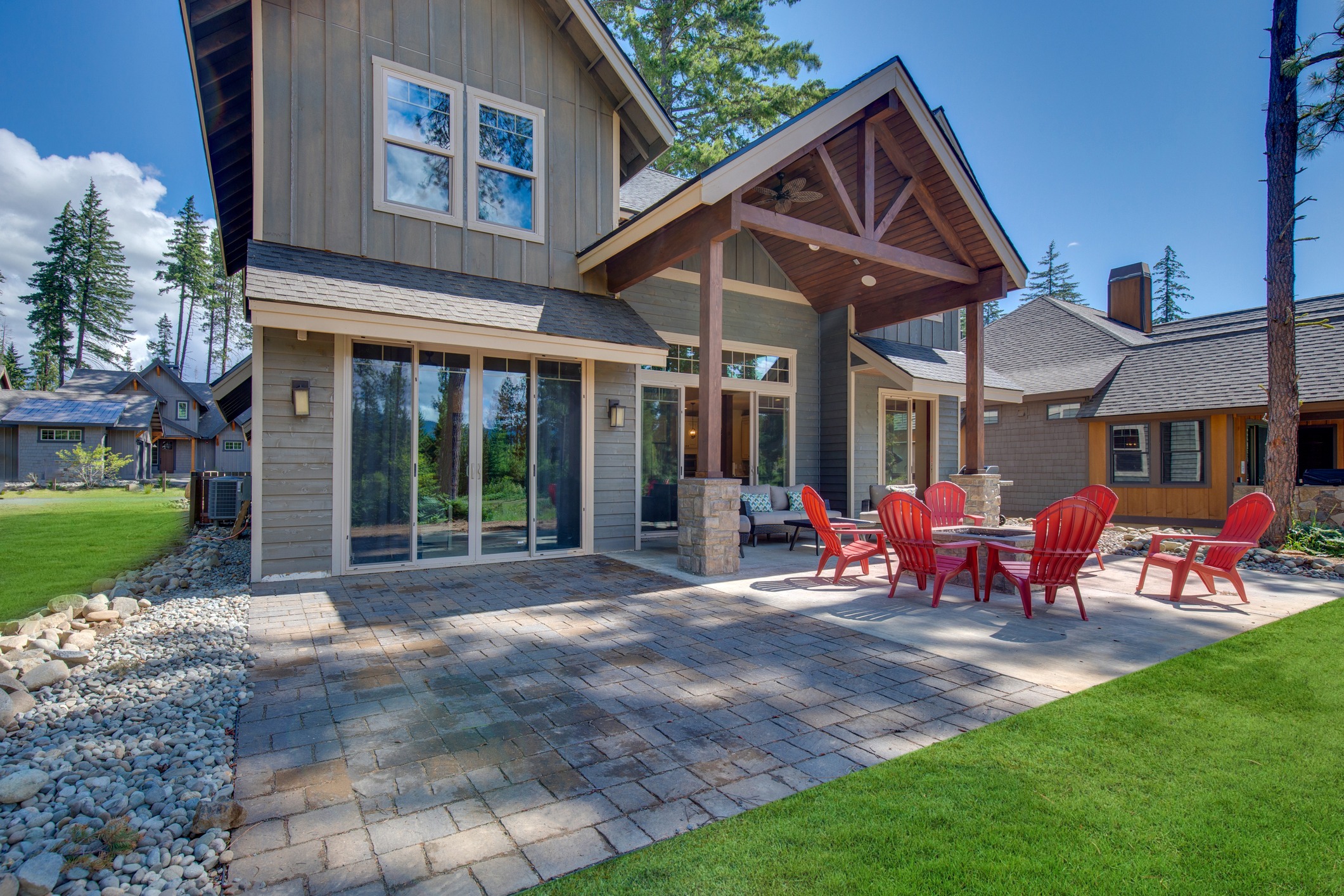 Modern house with outdoor patio and red chairs.