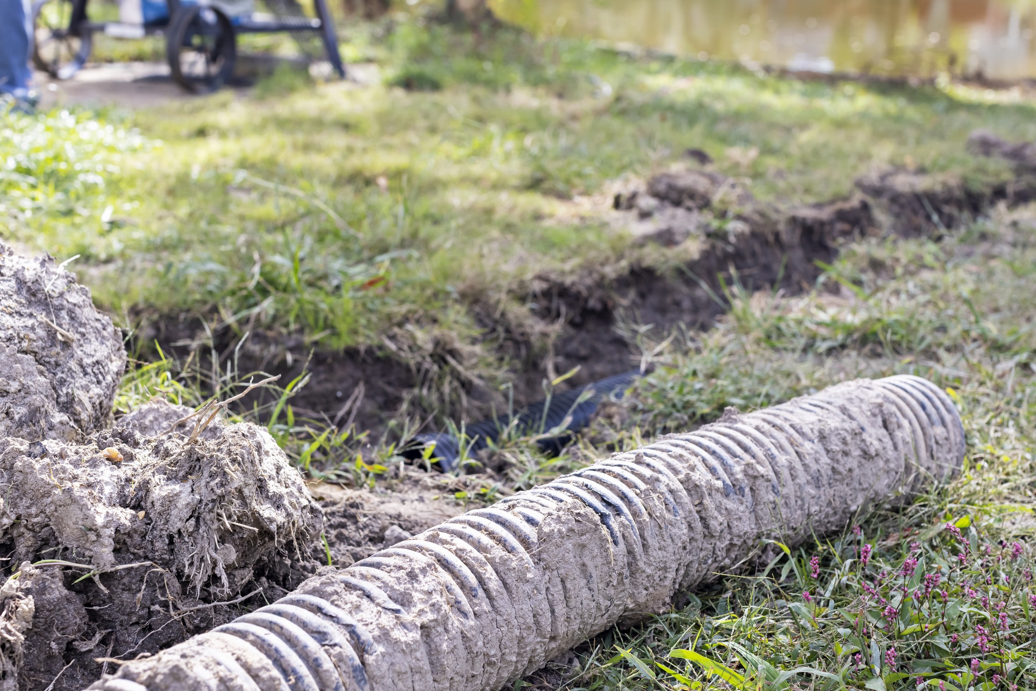 Outdoor drainage pipe in muddy trench