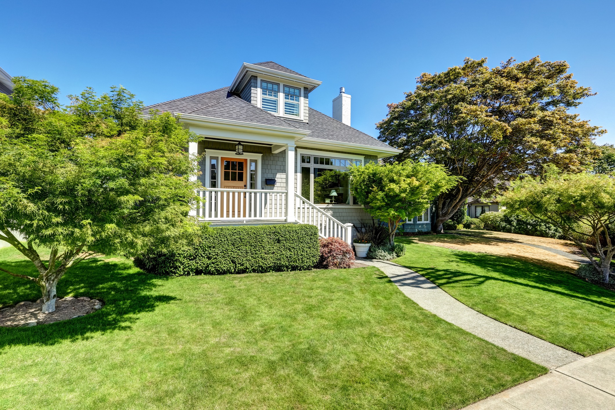 Charming house with front porch and manicured lawn.